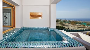 A rooftop infinity pool with mosaic tiles, a wooden door, and a framed artwork. - Alyvia Suites (Santorini)