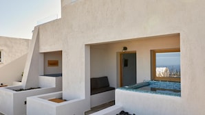A modern outdoor seating area with white planters and a small pool. - Alyvia Suites (Santorini)