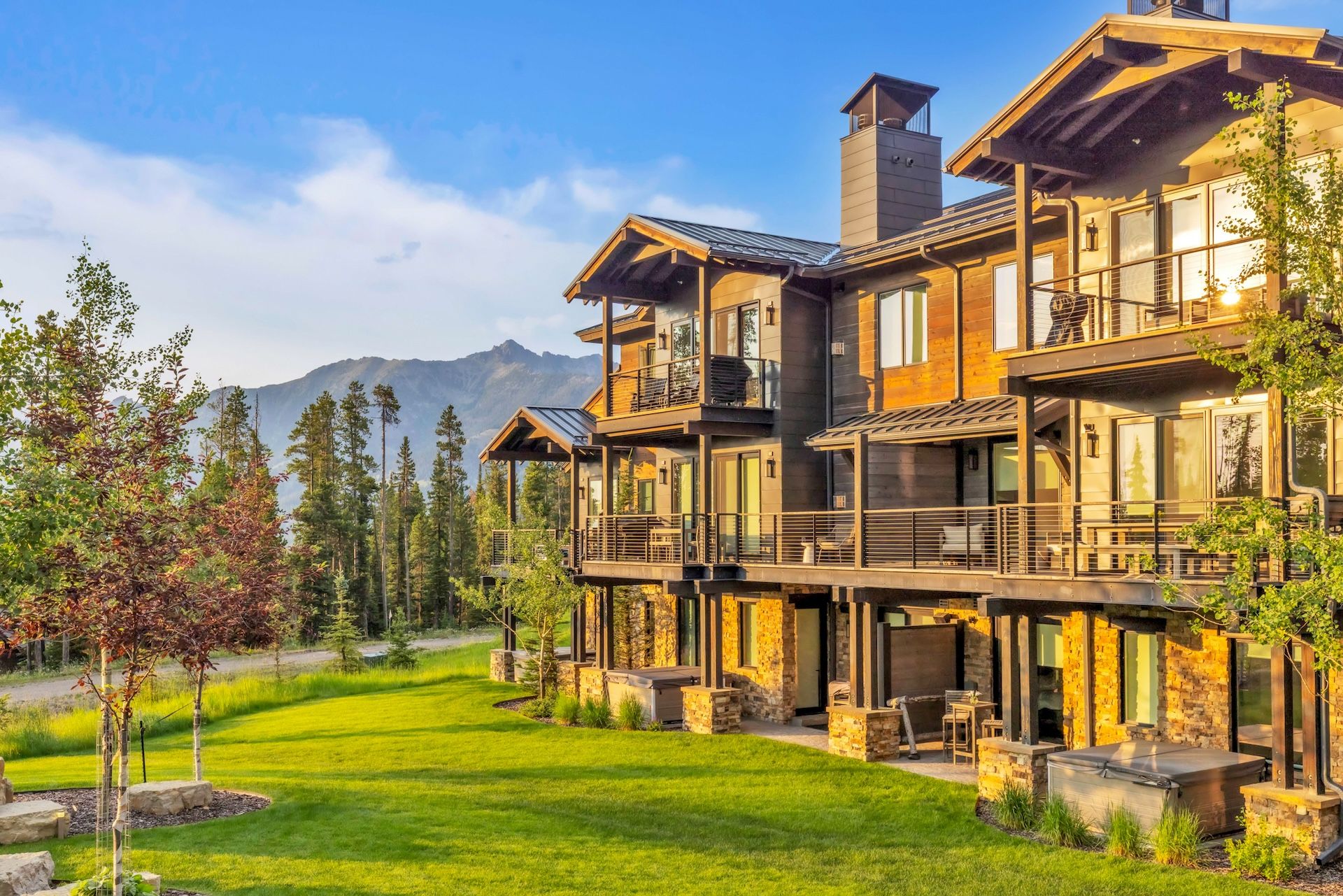 A multi-story house with a stone facade, large windows, and a balcony.