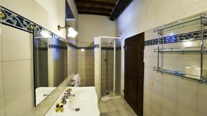Une salle de bain avec une grande baignoire, une douche à parois de verre et un miroir.