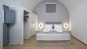 A bedroom with a bed, bedside lamps, a wardrobe, and a small window. - Casa Tholari Al Mare (Αστυπάλαια)