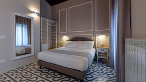 A bedroom with a bed, bedside tables, a mirror, a wardrobe, and a radiator. - Marie Claire Apartments Spa (Vasto)