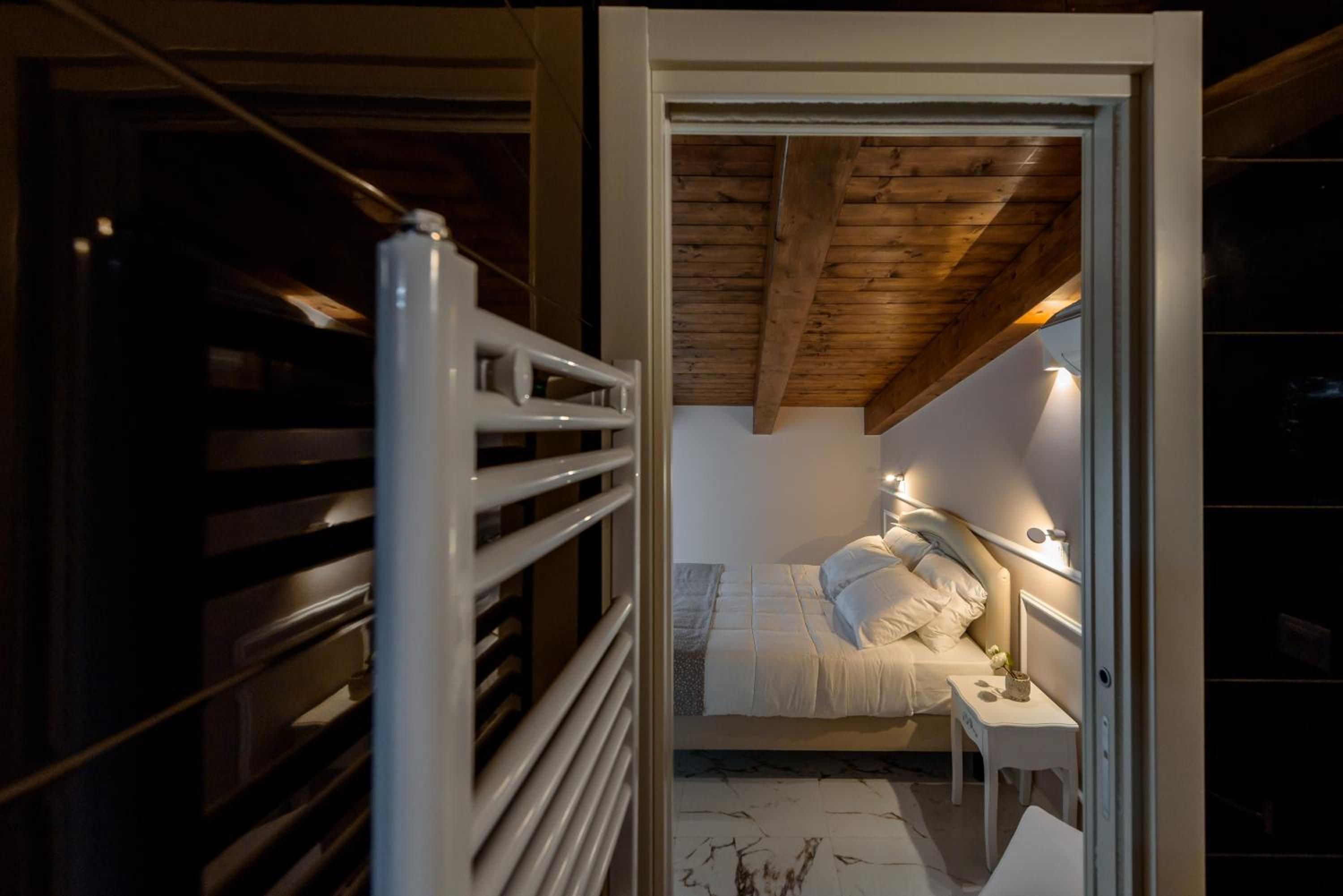 A bedroom with a bed, bedside table, and a radiator.