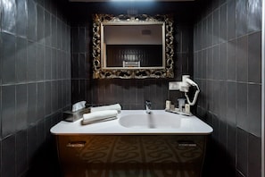 A bathroom with a large mirror, a sink, and a vanity with a patterned cabinet. - Marie Claire Apartments Spa (Vasto)