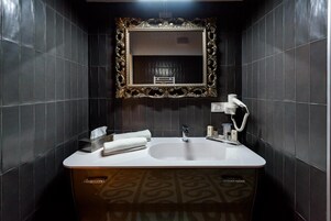 Un bagno con un grande specchio, un lavandino e un mobile contenitore con decorazioni.