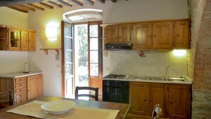 Una cocina rústica con armarios de madera, estufa a gas y pileta.