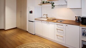 A modern kitchen with white cabinets, a wooden countertop, and a built-in sink. - Apartment near in Republic square  (Yerevan)