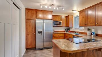A modern kitchen with wooden cabinets, stainless steel appliances, and a granite countertop.