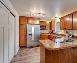 Una cucina moderna con mobili in legno, elettrodomestici in acciaio inossidabile e un piano di lavoro in granito.