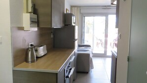 Una cocina compacta con tostadora, hervidor y refrigerador.