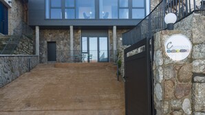 Un edificio moderno con fachada de piedra, una entrada amplia y un cartel que indica 'Carrizoza'.
