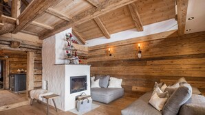 Ein Blockhaus-Interieur mit Kamin, Sofa und Holzbalken.
