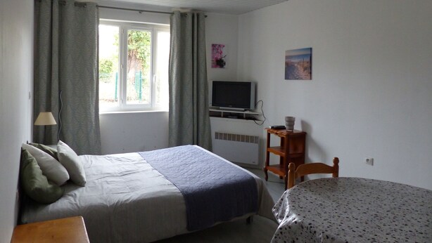 A room with a bed, a desk, a television, and a window with curtains. - La Calypso the 2-person studio (+ 1 child under 3) ideal for fishing (Blangy-sur-Bresle)