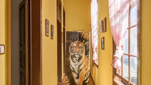 A hallway with a large tiger mural, wooden doors, and a window with a curtain. - Holiday Home "Casa Pollo Buen Lugar" with Rustic Charme & Terrace (Buenlugar)