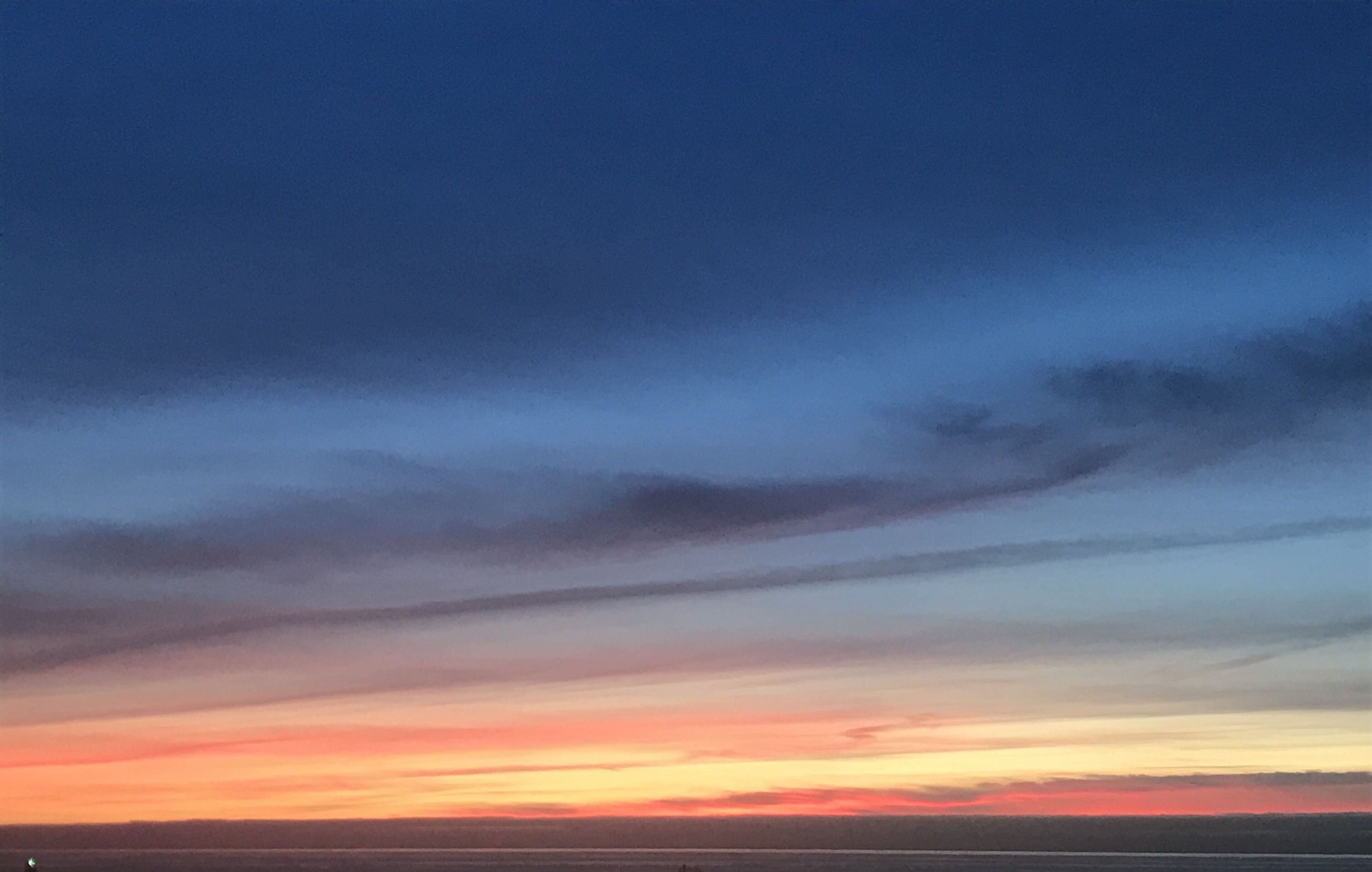 Un coucher de soleil sur un paysage plat, avec un horizon dégagé.
