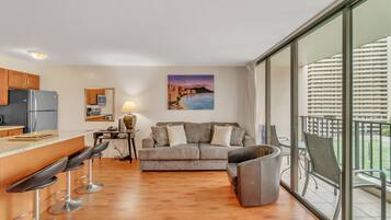Un apartamento moderno con cocina, comedor y balcón con vistas a la ciudad.