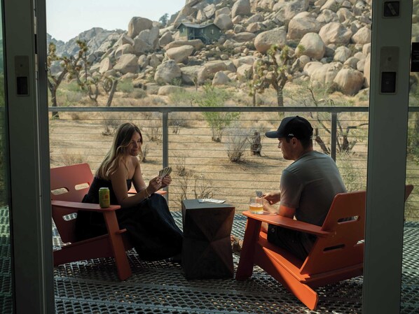 Two people seated at a table with a view of a rocky landscape.