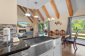 A modern kitchen with a large island, granite countertops, and a built-in sink.