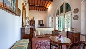Una habitación acogedora con una cama, una mesa de comedor y un sofá. Hay platos decorativos en la pared y un cuadro sobre la cama.