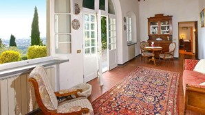 Una habitación amplia con un gran ventanal, techo de madera y alfombra tradicional.