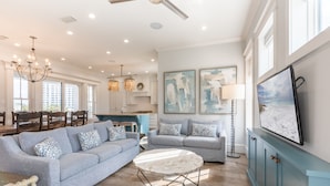 A spacious living room with a large sofa, a coffee table, and a TV mounted on the wall. - Lake Views ~ Private Pool ~ Outdoor Lounge Area (Destin)