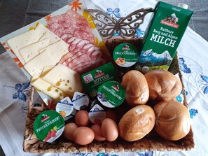 A variety of food items including cheese, salami, bread, and dairy products.