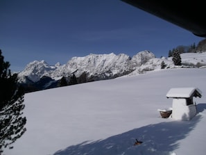 A snow-covered mountain landscape with a small cabin.