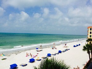 Na praia, espreguiçadeiras, toalhas de praia 