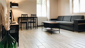 Ein modernes Wohnzimmer mit einer Couch, einem Couchtisch und einem Essbereich mit Stühlen.