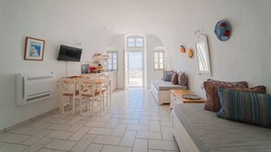 Un vaste espace de vie comprenant une table à manger, un canapé et un téléviseur.