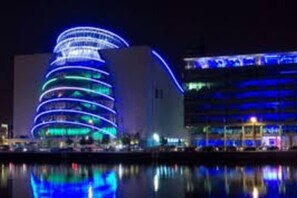 A modern building with a circular design and illuminated blue lights.