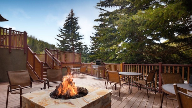 An outdoor deck with a fire pit, seating, and a barbecue grill. - Unit inside a Luxury resort + heated pool (Vail)