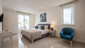 Un dormitorio moderno con cama, mesitas de noche, una silla y un ventanal grande.
