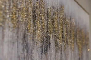 A close-up of a textured wall with vertical lines and glittery gold accents. - Waters Avenue Unit B (Tampa)