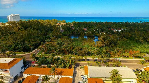 A coastal area with a road, buildings, and a large body of water. - Tangerine Sunsets Seville (Nassau)