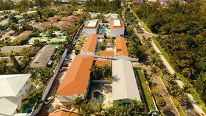 An aerial view of a residential area with multiple buildings, roads, and greenery. - Tangerine Sunsets Seville (Nassau)