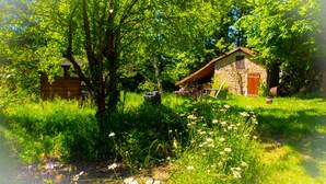 A rustic stone house with a wooden door and a small garden with various plants and flowers. - Cottage - Peaceful and nature (Cieux)