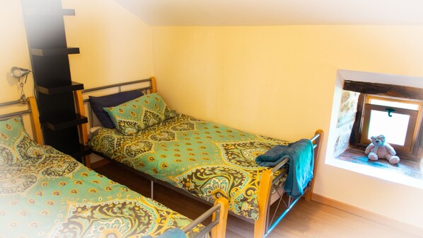 A dormitory room with two single beds, a window with a teddy bear, and a small shelf with a lamp. - Cottage - Peaceful and nature (Cieux)