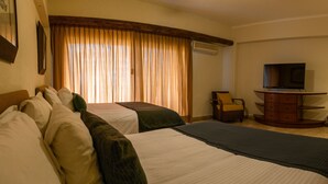 A hotel room with two beds, a television, a chair, and a desk. - Beautiful Studio with balcony inside resort (Puerto Vallarta)