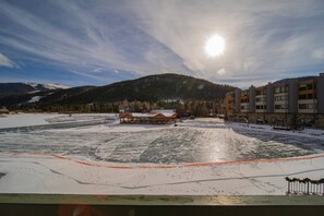 A snow-covered landscape with a wooden building and modern apartments. - Lakeside 1476 (Keystone)