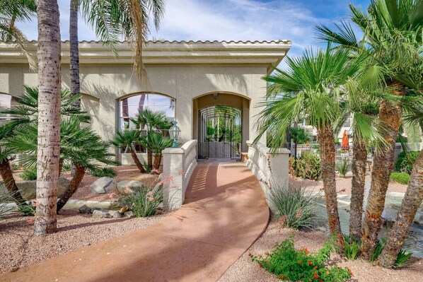 A house with a curved driveway, palm trees, and a gated entrance. - Regency Resort Luxury Condo (Scottsdale)