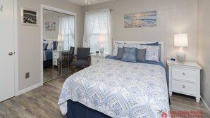 A bedroom with a large bed, a ceiling fan, a desk, and a chair. - Spacious Townhome ~ Pet Friendly ~ Great Beach Location! (Saint Augustine)