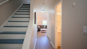 A staircase leading to a living area with a sofa and a coffee table. - Beautiful Townhome Steps from Beach (Indian Shores)