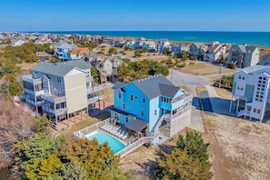 Un quartier résidentiel situé sur la côte, avec des maisons, une piscine et une vue sur l’océan.