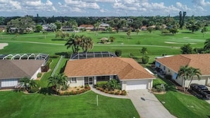 Zona residencial amb cases, un camp de golf i un cel serè.