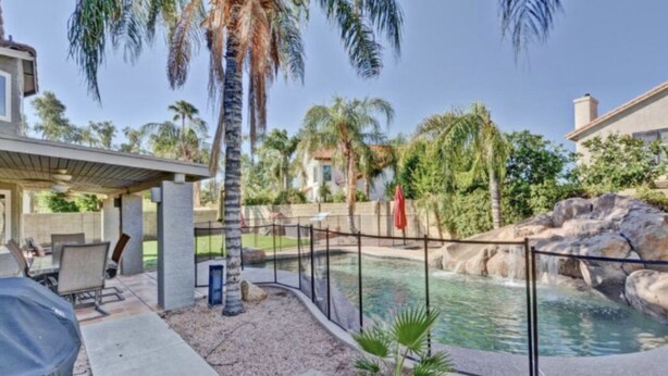 A backyard with a pool, palm trees, and a covered patio area. - 🔥HEATED Pool, Pool Table, Golf, and Spring Training (Glendale)
