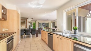 A modern kitchen with a central island, built-in oven, and dishwasher.