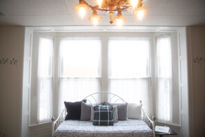 A bedroom with a bed, a chandelier, and a window with curtains. - Sleeps 5 Fully Equipped Apartment Near Golf Courses (Corry)