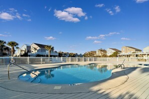 Relax by the pool surrounded by a deck and a fence, offering a serene atmosphere.