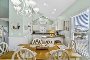 Enjoy meals in this well-appointed kitchen with a central island, dining table, and large windows offering a view.